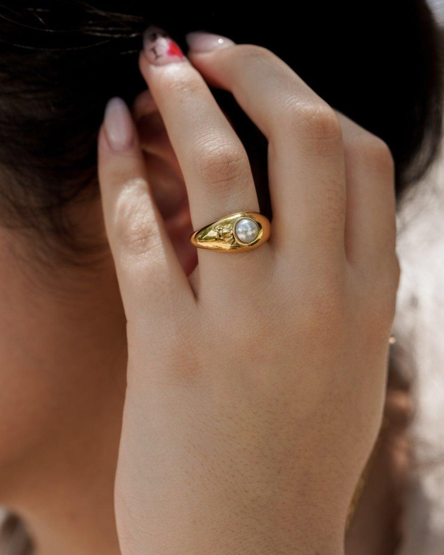 Model Image - Pearl ring with a simple band shown on a hand near the face worn on model