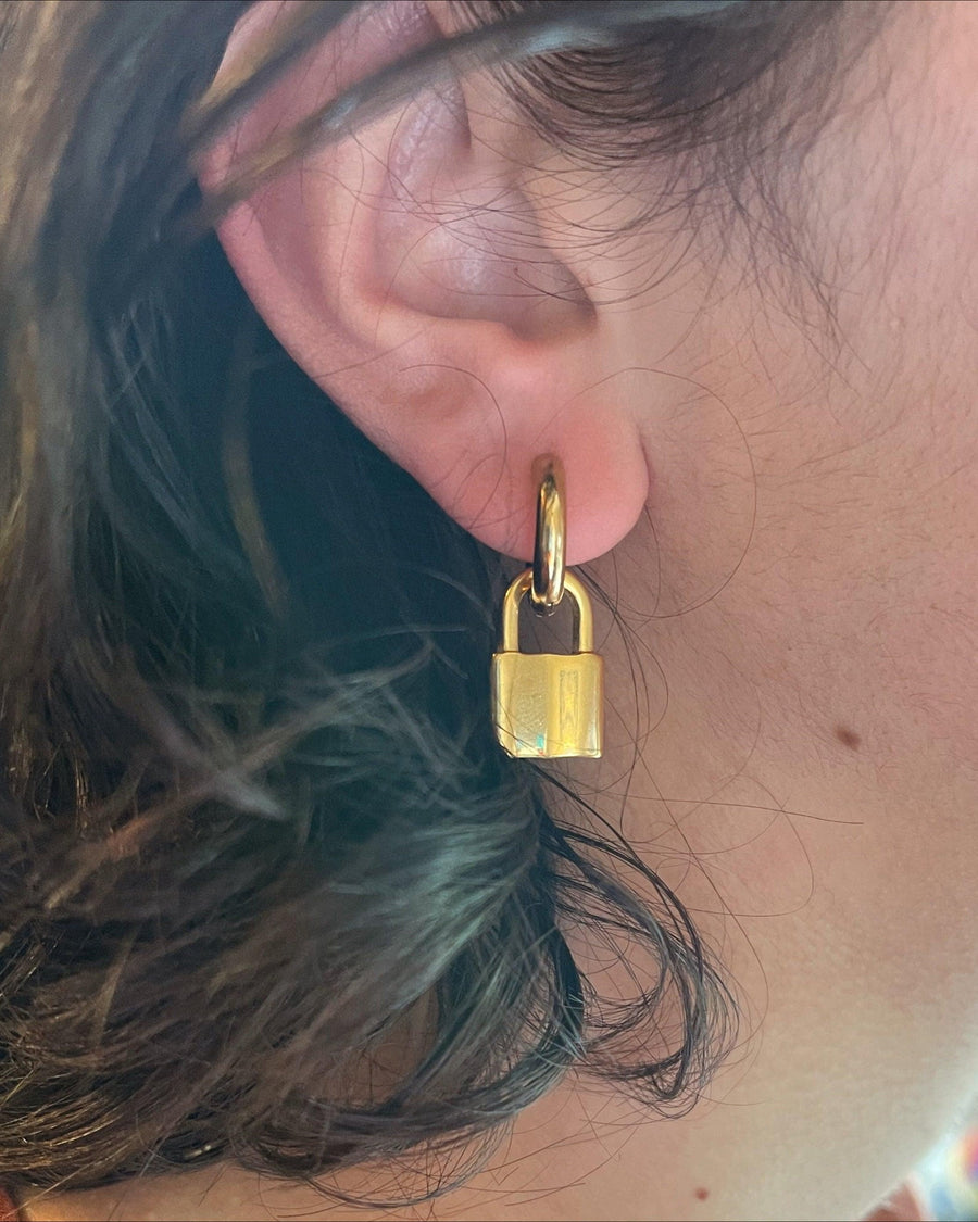 Model Image - Padlock hoop earring with a dangling padlock shape worn on model