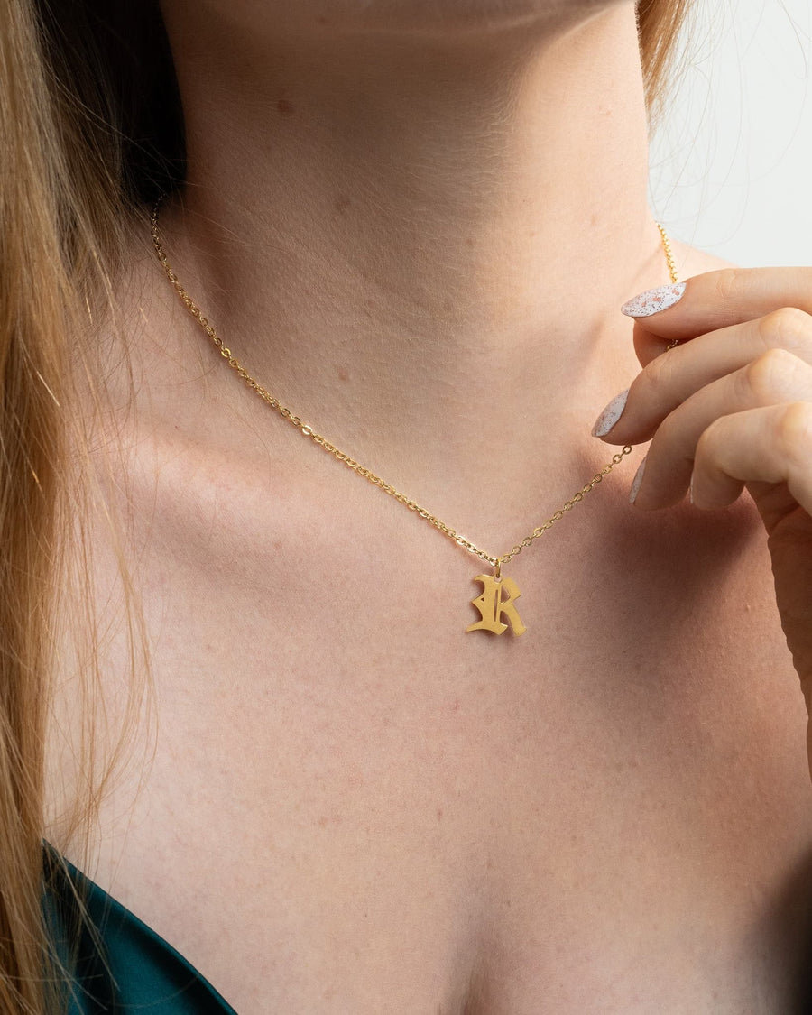 Model Image - Old English initial necklace with letter R pendant at the neckline worn on model