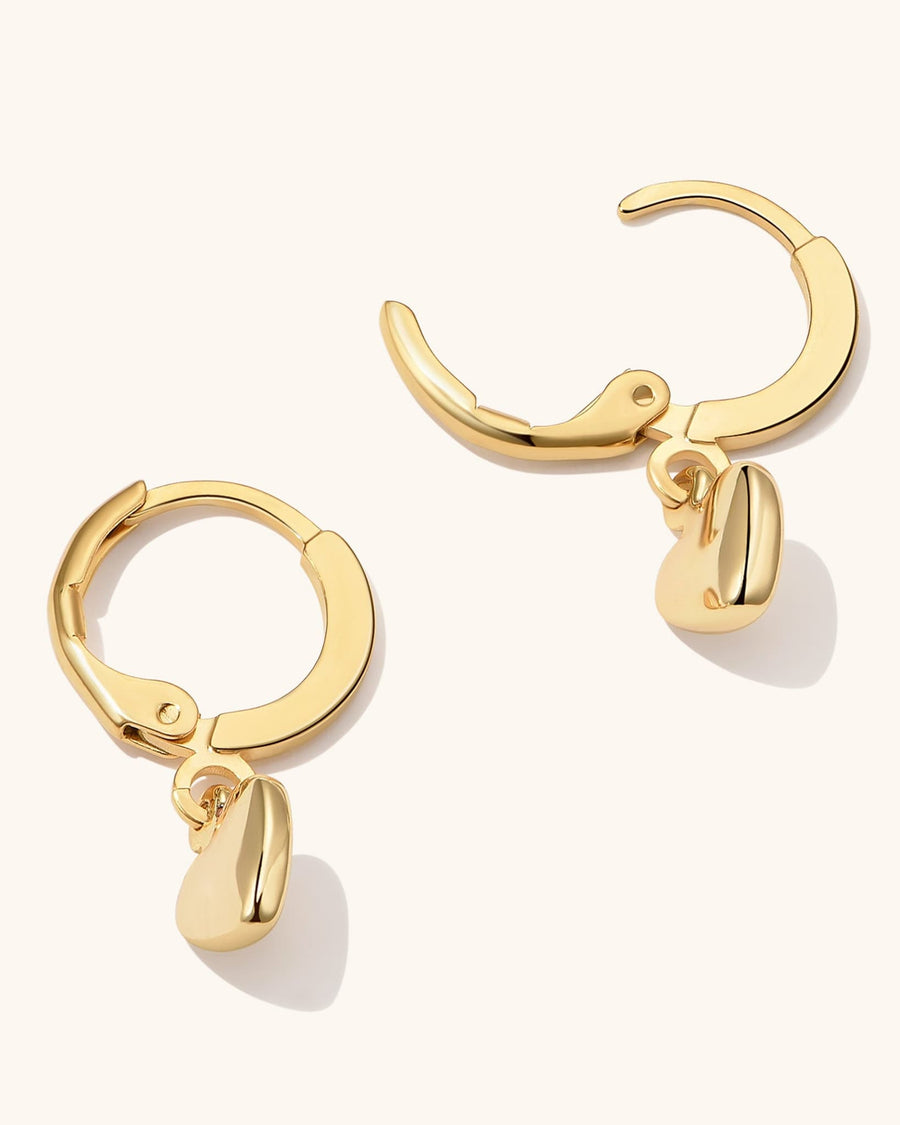 Model Image - 14k gold plated puffy heart hoop earrings with dangling heart charms worn on model