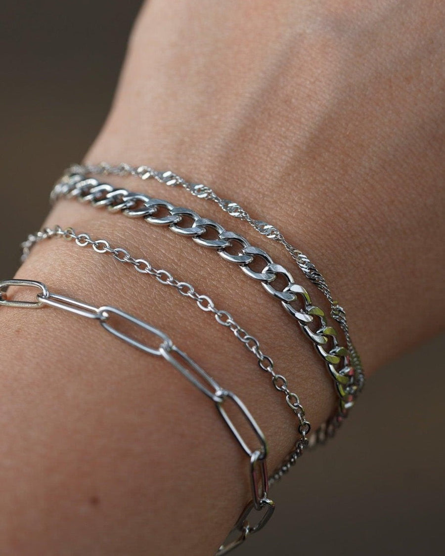 Model Image - delicate silver cable chain bracelet layered with other silver bracelets on the wrist worn on model