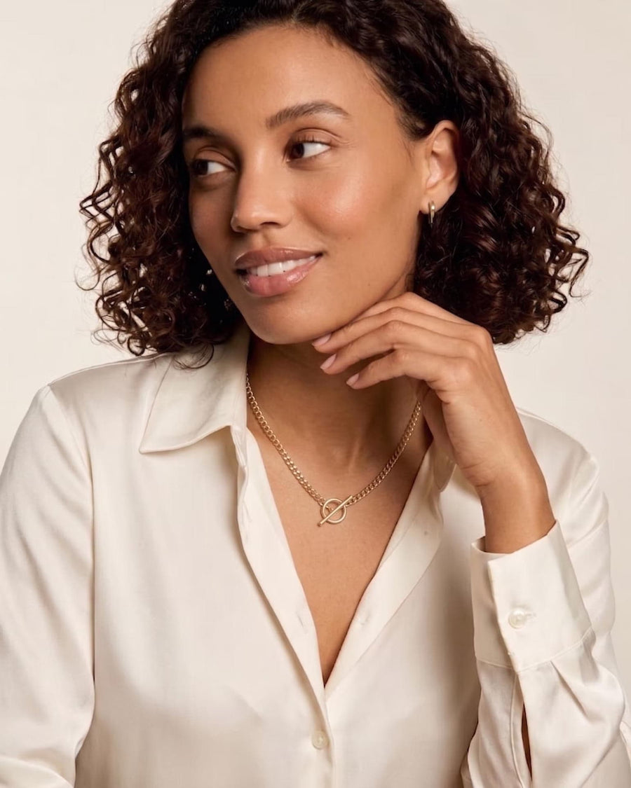 Model Image - 18k gold bold curb chain necklace with front toggle closure styled close to the neck worn on model